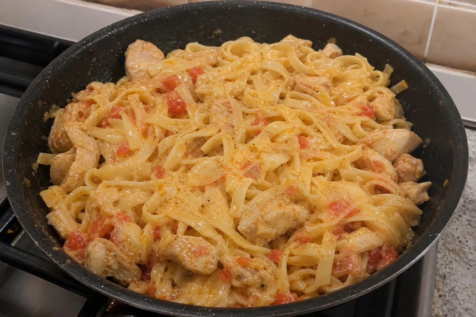 Лапша с курицей, помидорами и сыром на сковороде